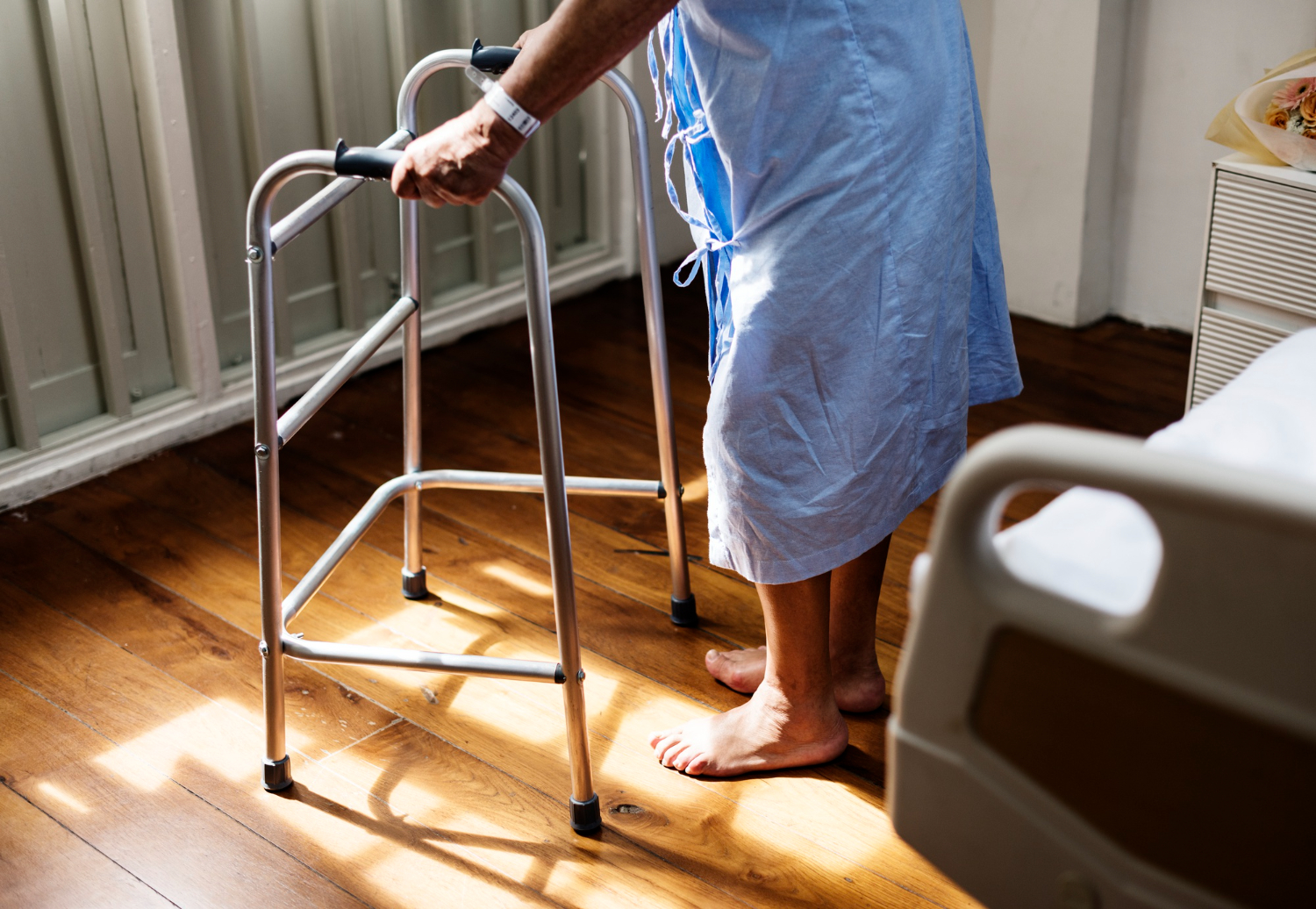 Pflegefachperson stützt eine ältere Frau beim Gehen